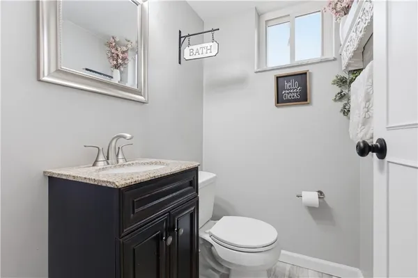 a bathroom with a granite countertop sink toilet and mirror