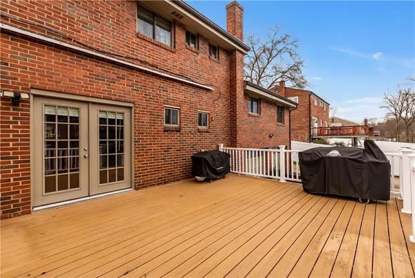 a view of a house with a barbeque and wooden floor