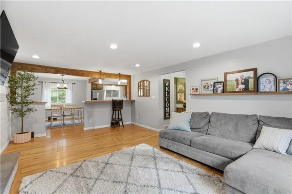 a living room with furniture and view of kitchen