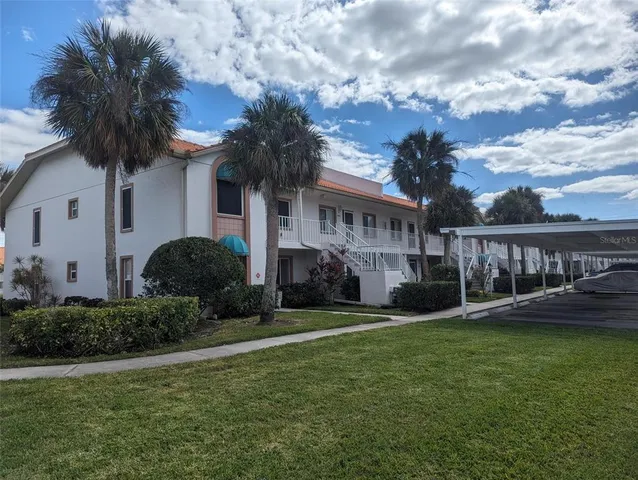 a view of a house with a yard and potted plants