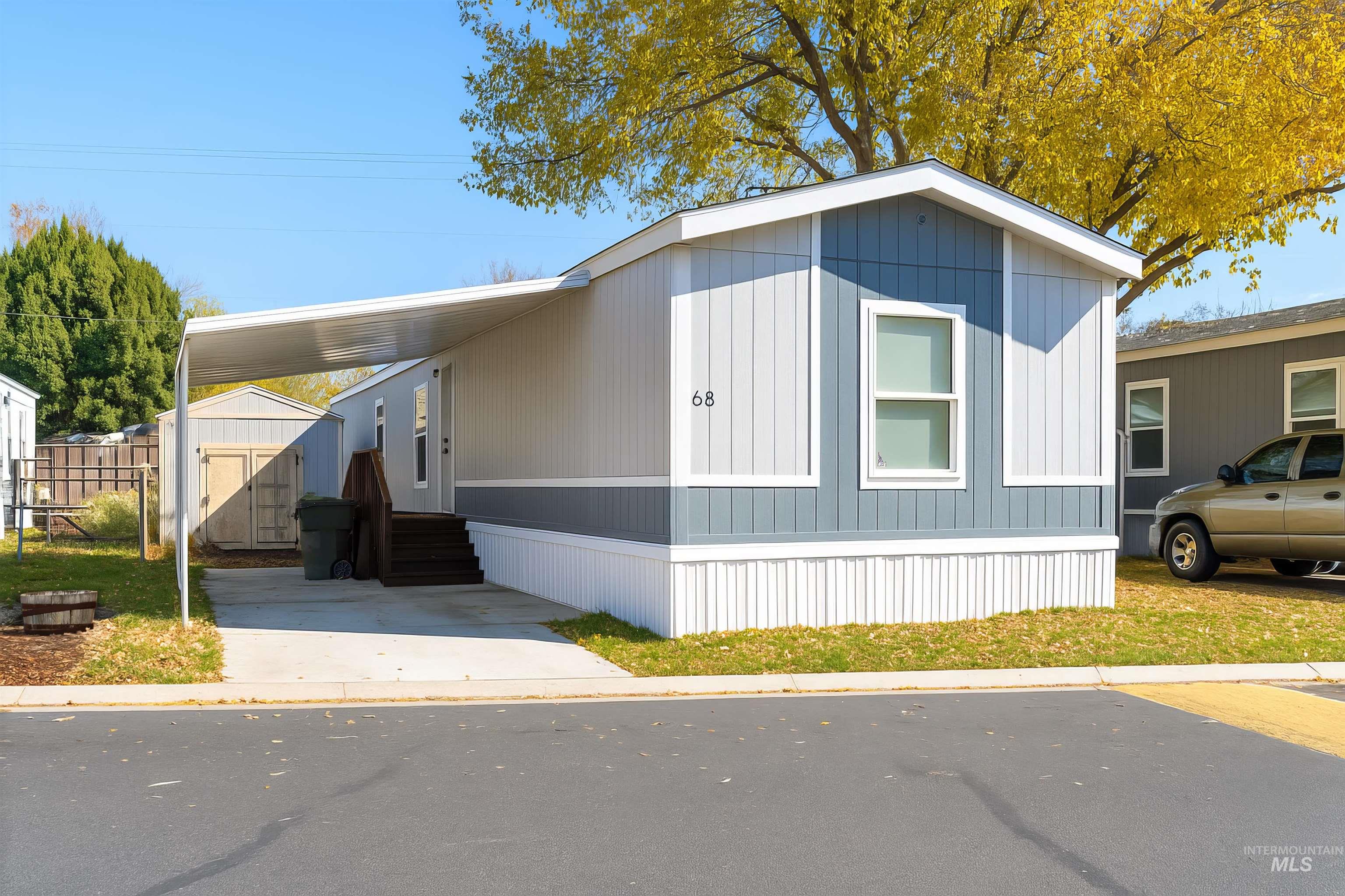 Manufactured / mobile home featuring a storage unit, an attached carport, and entry steps
