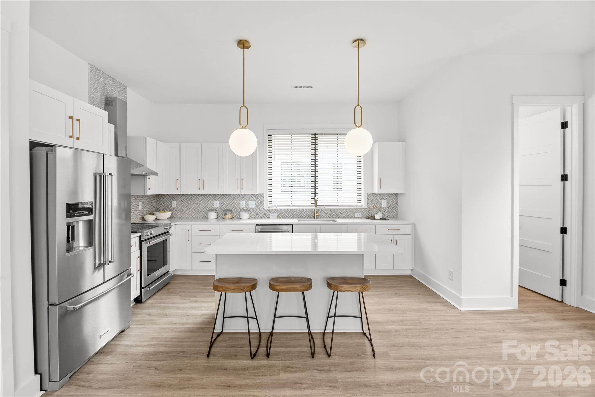 4041 South Tryon Street Charlotte, NC 28217 - Photo 13 of 45 a room with stainless steel appliances kitchen island granite countertop a table chairs stove and wooden floor