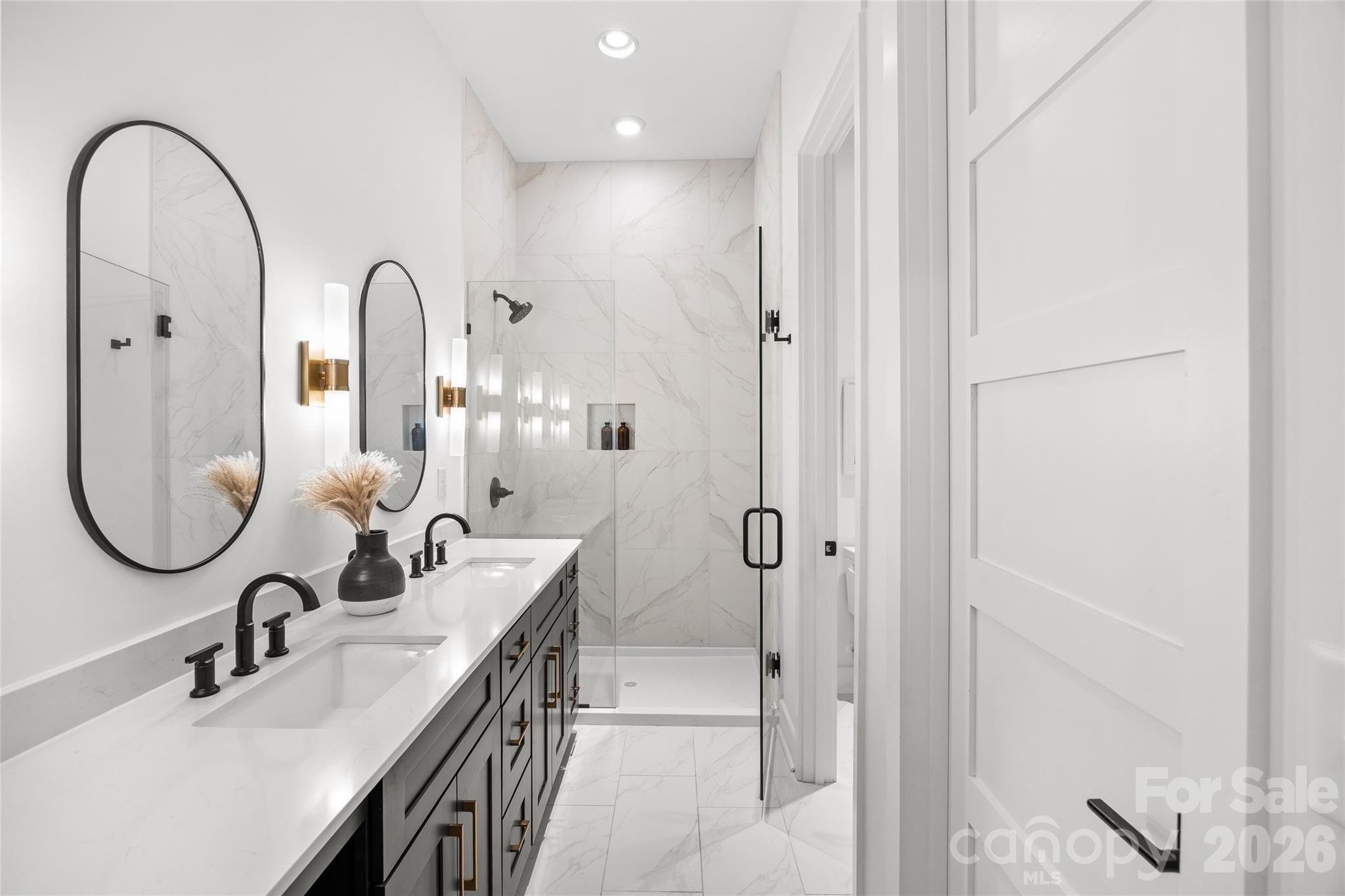 4041 South Tryon Street Charlotte, NC 28217 - Photo 38 of 45 a en suite bathroom with a granite countertop sink a mirror and shower