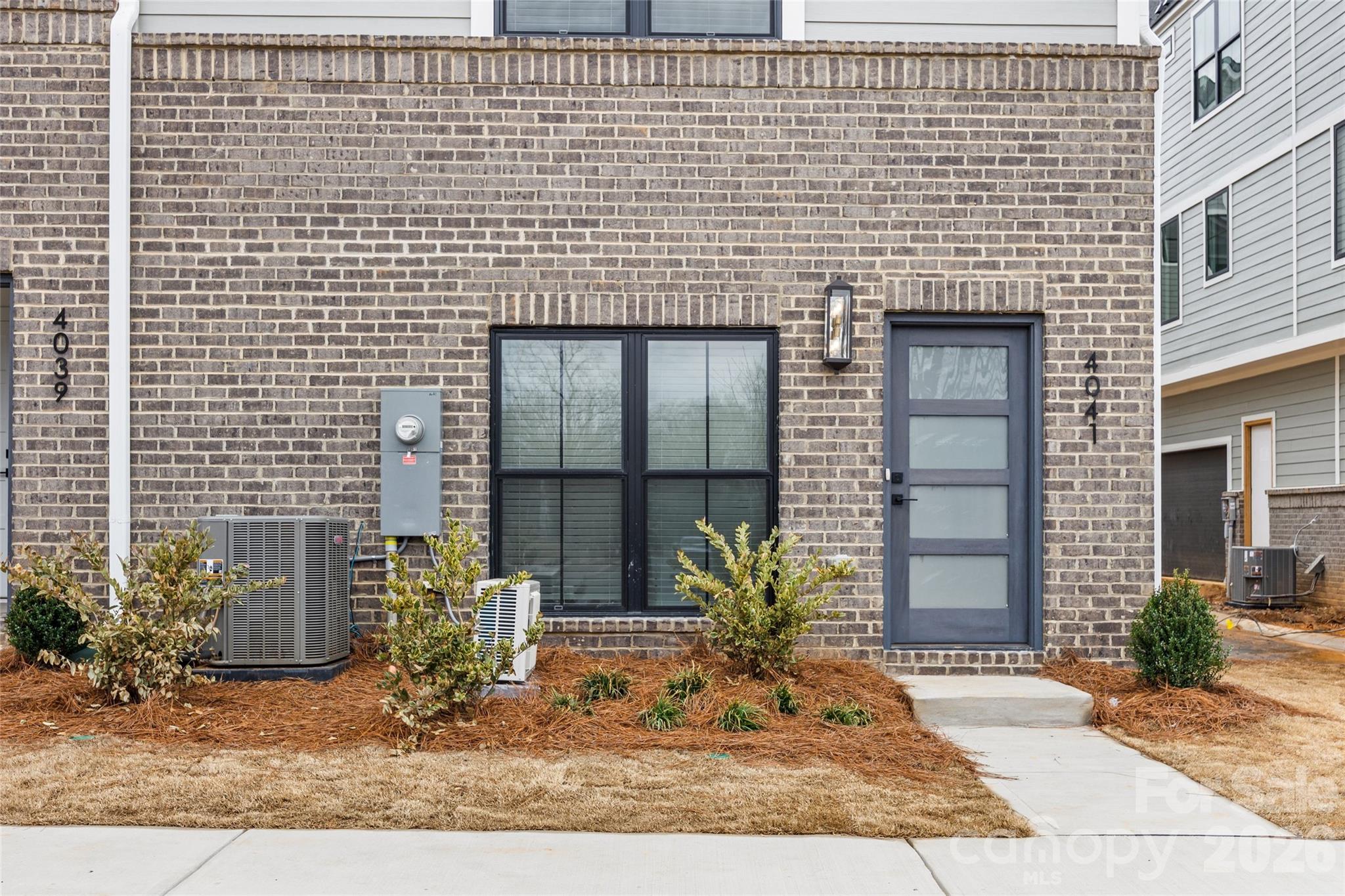 4041 South Tryon Street Charlotte, NC 28217 - Photo 5 of 45 a view of a brick house with potted plants