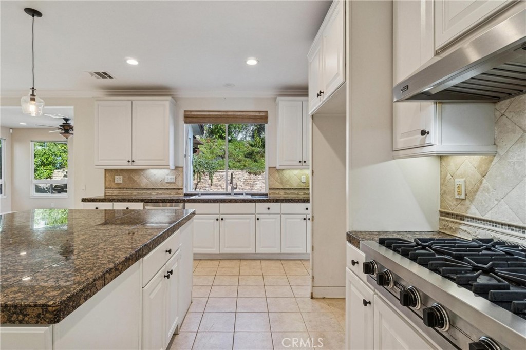 26511 Brooks Circle Stevenson Ranch, CA 91381 - Photo 13 of 65 a kitchen with granite countertop a sink stove and cabinets