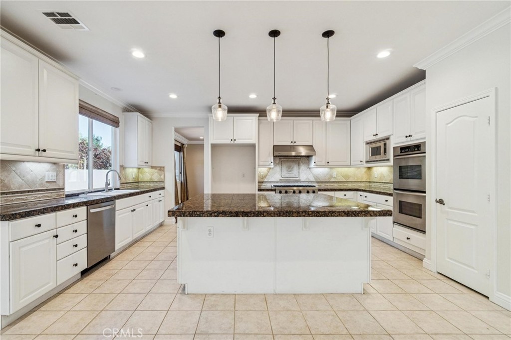 26511 Brooks Circle Stevenson Ranch, CA 91381 - Photo 14 of 65 a large kitchen with stainless steel appliances granite countertop a stove a sink and a refrigerator