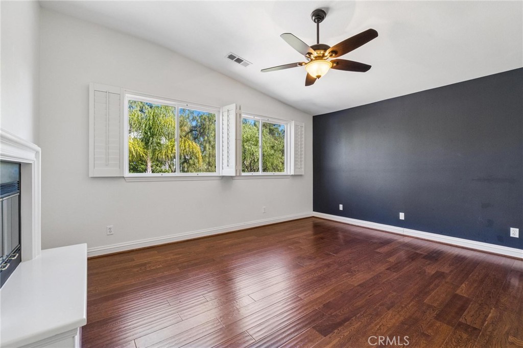 26511 Brooks Circle Stevenson Ranch, CA 91381 - Photo 25 of 65 a view of an empty room with wooden floor and a ceiling fan