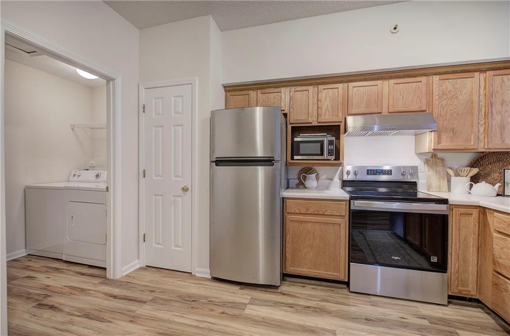 150 Old Mill Road, Unit 205 Cartersville, GA 30120 - Photo 14 of 32 a kitchen with a refrigerator stove and white cabinets