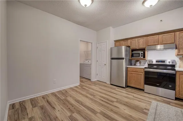 a kitchen with a refrigerator a sink and cabinets
