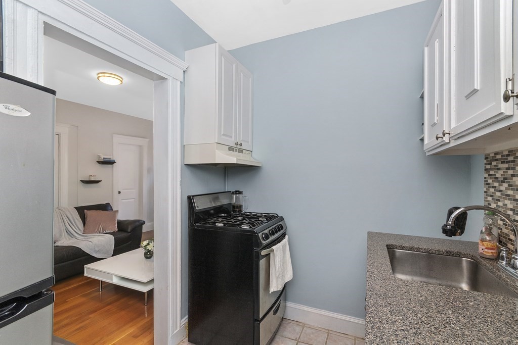 62 Queensberry Street, Unit 407 Boston, MA 02215 - Photo 9 of 14 a kitchen with stainless steel appliances granite countertop a stove and a wooden cabinets