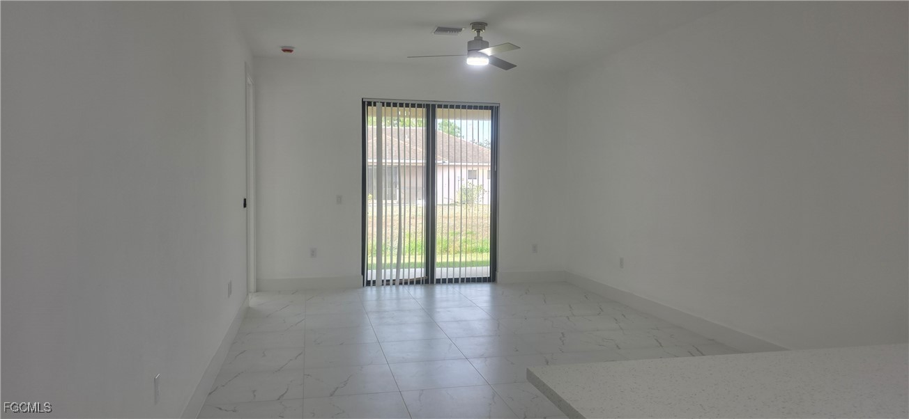 925 Chenault Street Lehigh Acres, FL 33974 - Photo 5 of 16 a view of an empty room with wooden floor and a window