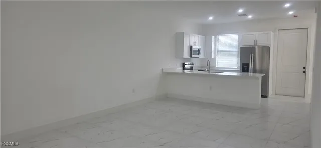 an empty room with a window and ceiling fan