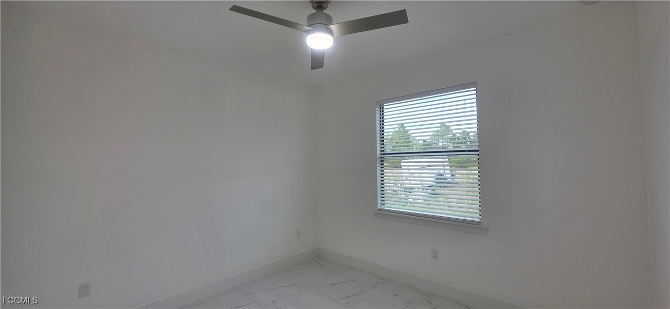 925 Chenault Street Lehigh Acres, FL 33974 - Photo 8 of 16 an empty room with a window and ceiling fan