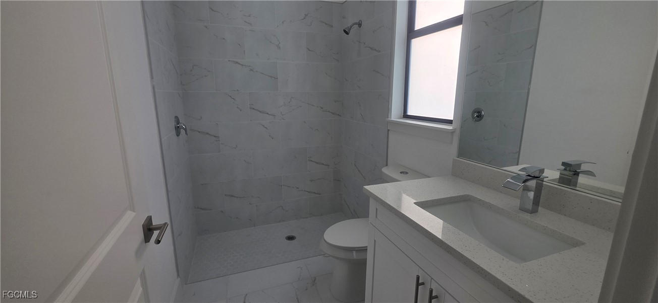 925 Chenault Street Lehigh Acres, FL 33974 - Photo 9 of 16 a bathroom with a sink toilet and shower