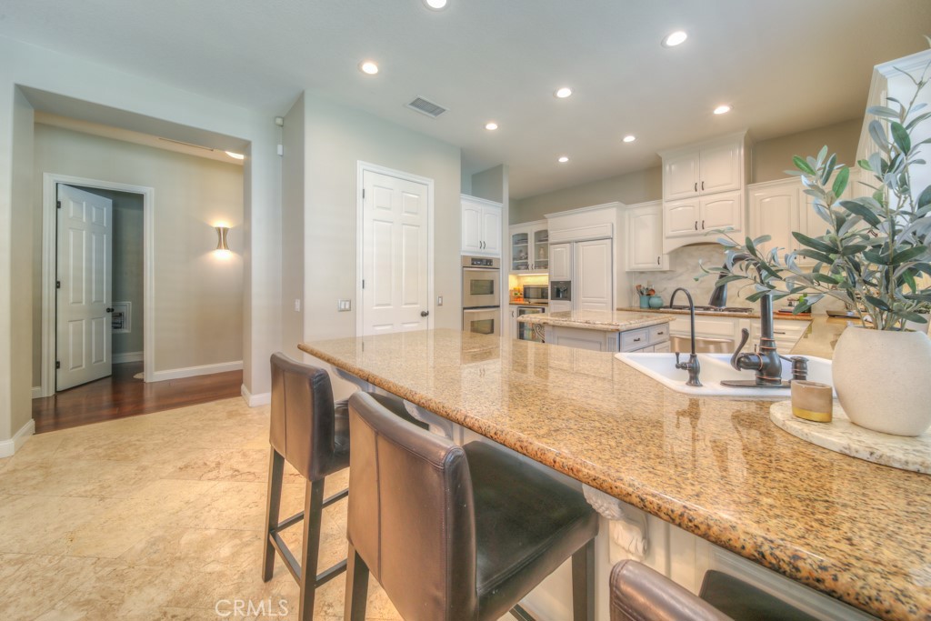 30370 Vía El Delora Temecula, CA 92592 - Photo 27 of 75 a view of a kitchen with kitchen island a sink stainless steel appliances and living room view