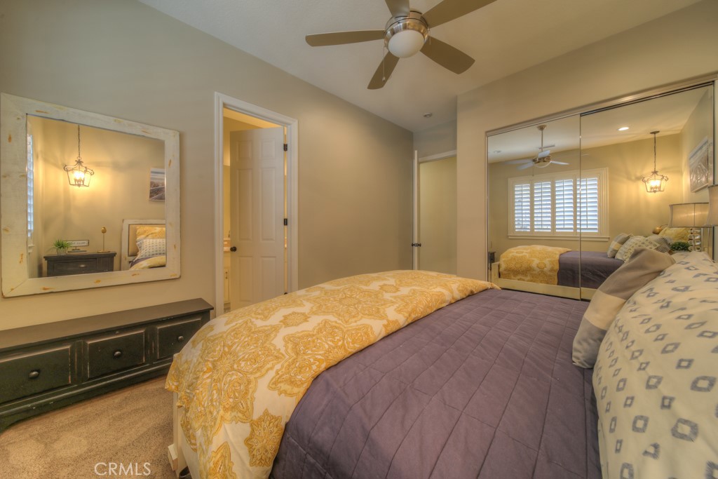 30370 Vía El Delora Temecula, CA 92592 - Photo 32 of 75 a bedroom with a bed and a large mirror with a chandelier