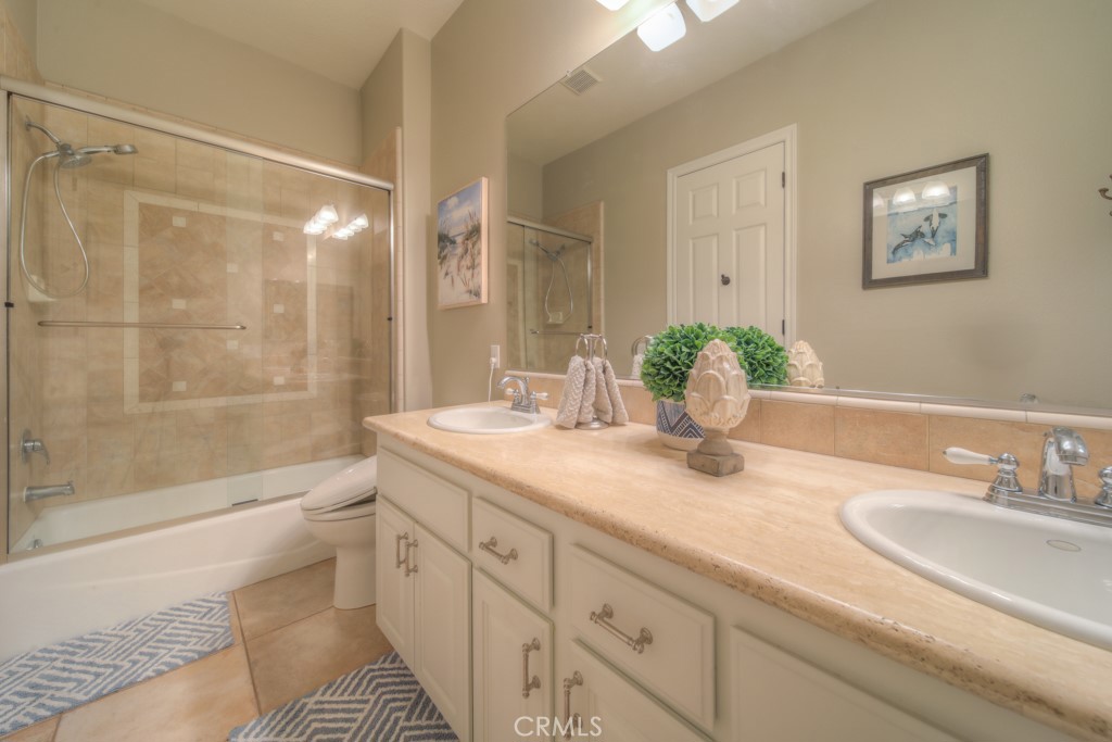 30370 Vía El Delora Temecula, CA 92592 - Photo 33 of 75 a bathroom with a granite countertop sink a mirror a bathtub and shower
