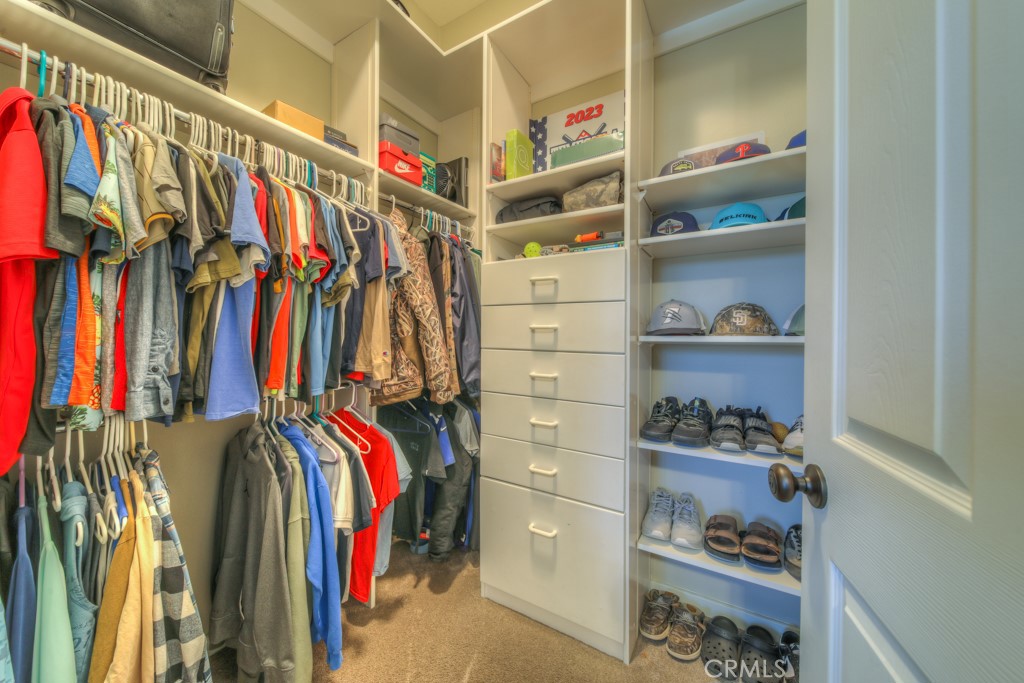 30370 Vía El Delora Temecula, CA 92592 - Photo 36 of 75 a view of walk in closet with clothes and shoes