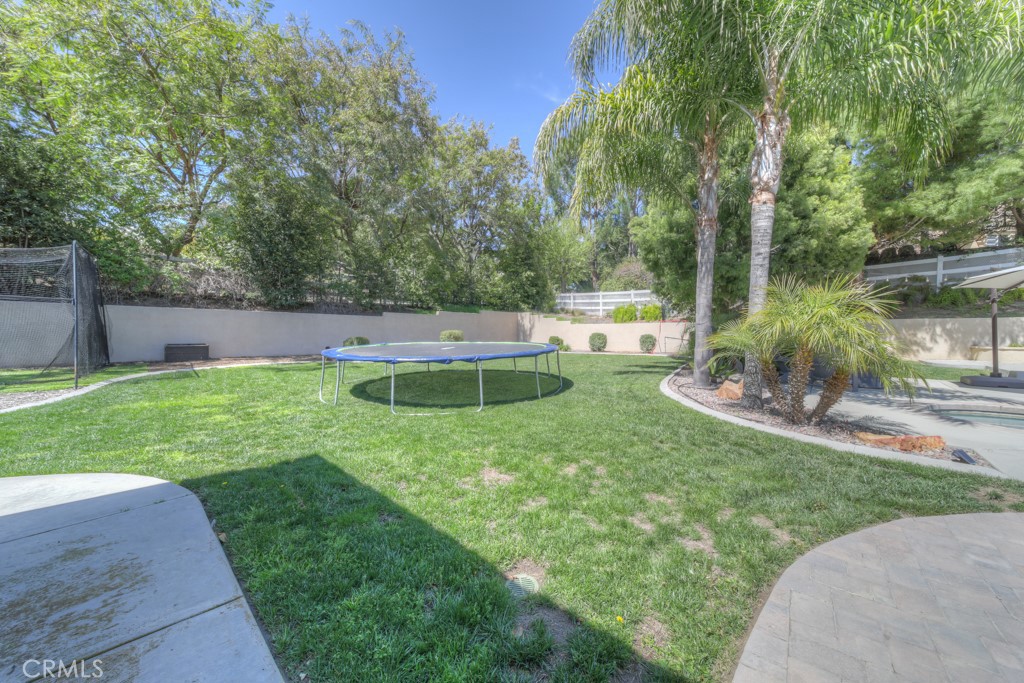 30370 Vía El Delora Temecula, CA 92592 - Photo 51 of 75 a view of a backyard with table and chairs potted plants and large tree