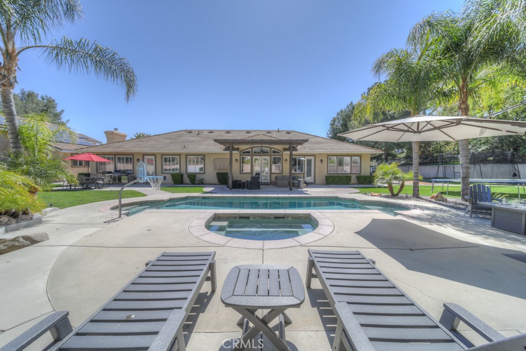 30370 Vía El Delora Temecula, CA 92592 - Photo 57 of 75 a view of a patio with a table and chairs under an umbrella