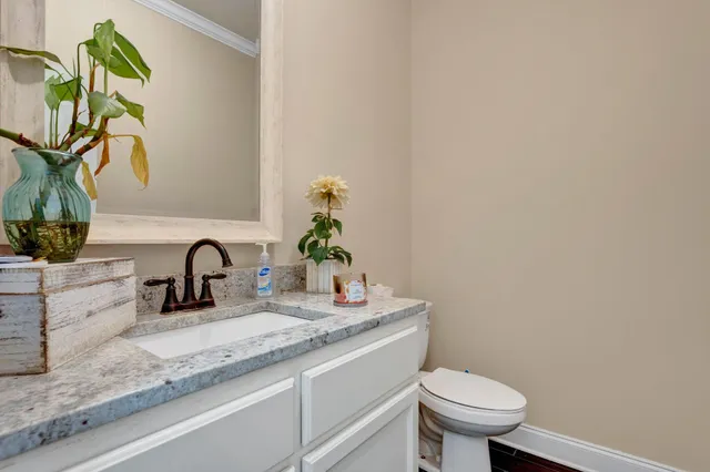 a bathroom with a granite countertop sink and a toilet