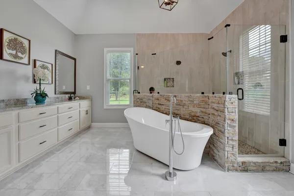 a spacious bathroom with a granite countertop tub sink and mirror