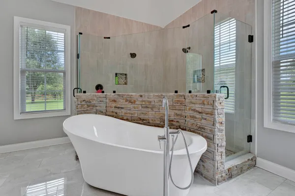 a bathroom with a tub and a large window