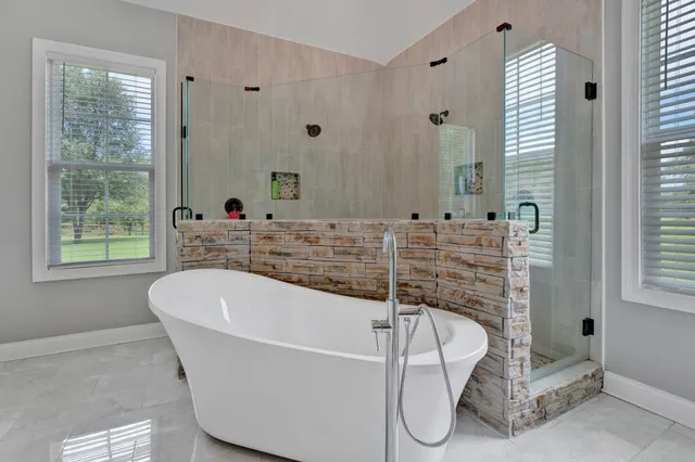 a bathroom with a tub and a large window