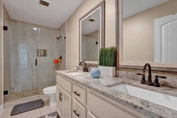 a bathroom with a granite countertop sink mirror and toilet
