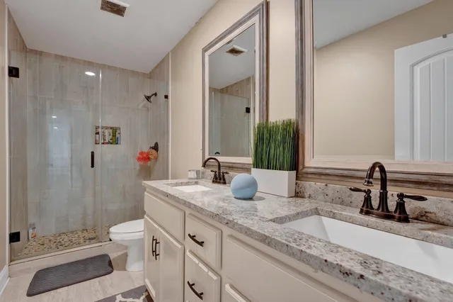 a bathroom with a granite countertop sink mirror and toilet