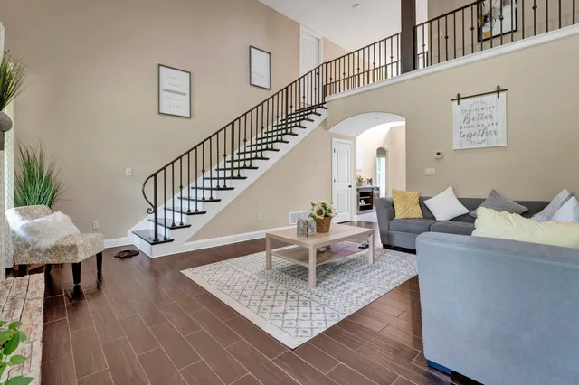 a living room with furniture and a dining table with wooden floor