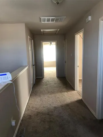 a view of hallway with stairs and wooden floor