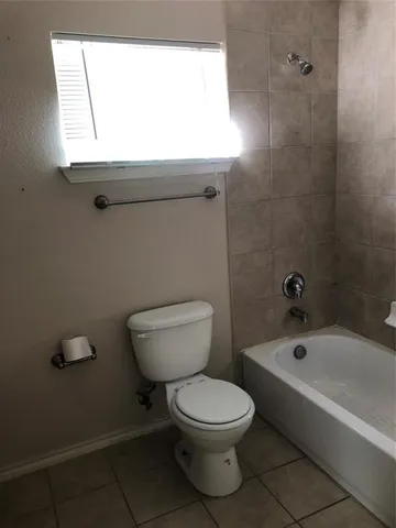 a white toilet sitting next to a bath tub
