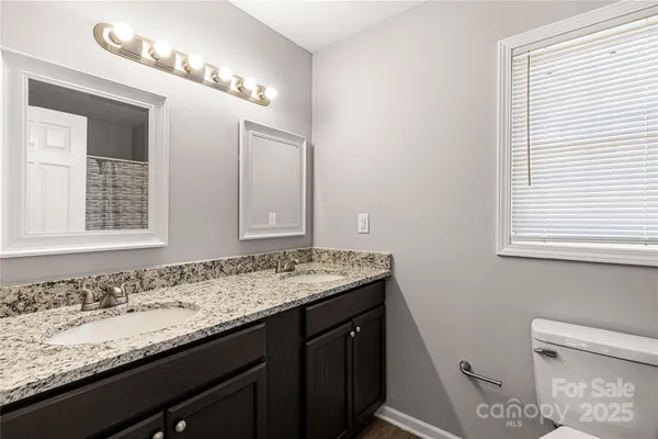 an empty room with windows and ceiling fan