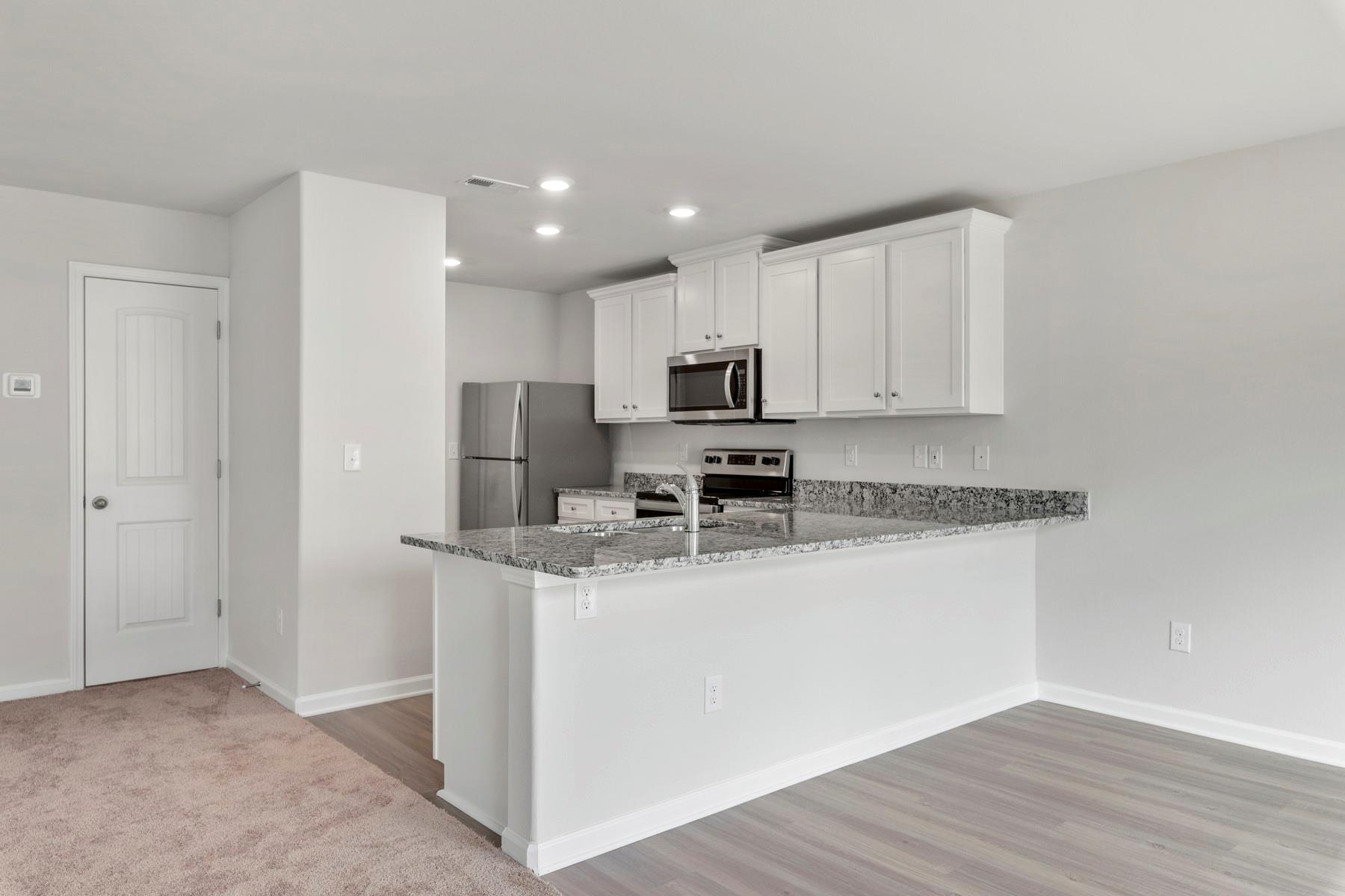 1405 Nia Road Charlotte, NC 28215 - Photo 7 of 16 a kitchen with stainless steel appliances granite countertop a sink a stove a refrigerator a microwave and cabinets