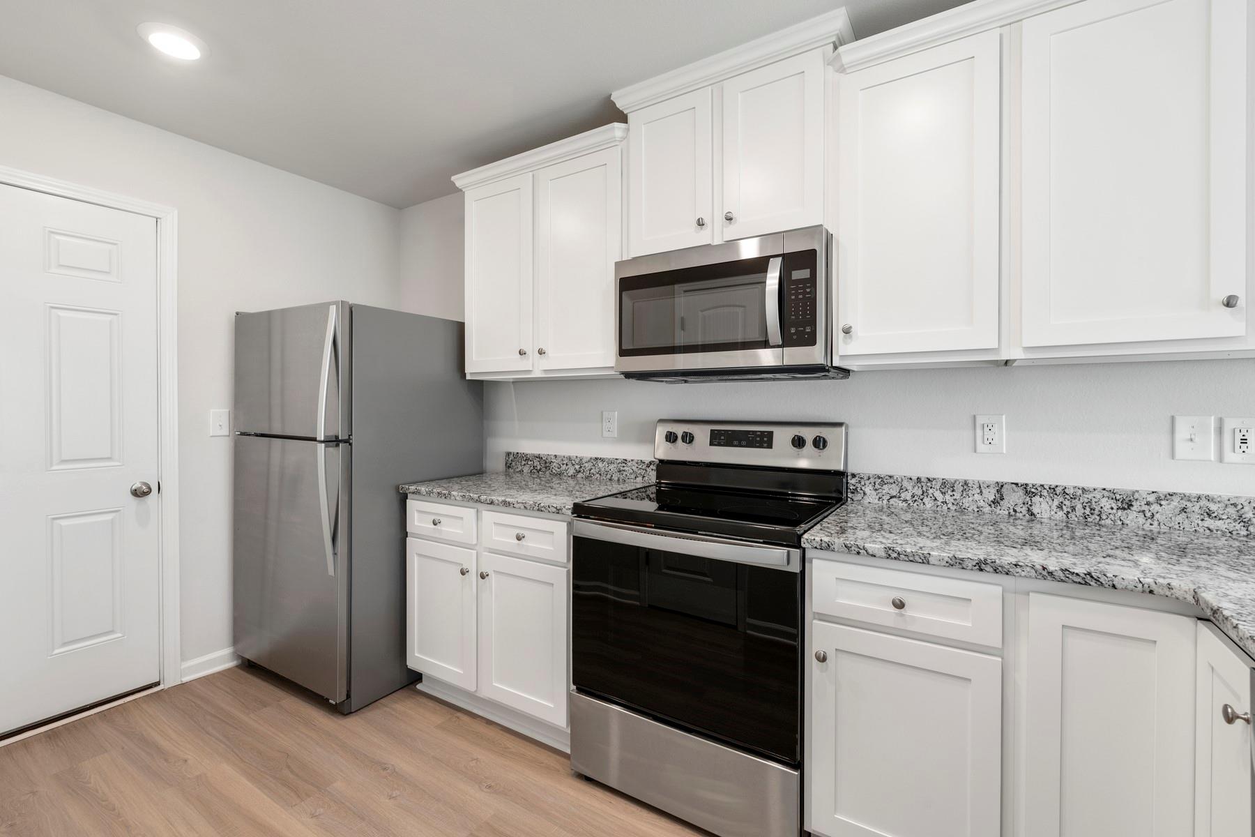 1405 Nia Road Charlotte, NC 28215 - Photo 9 of 16 a kitchen with cabinets stainless steel appliances and a wooden floor