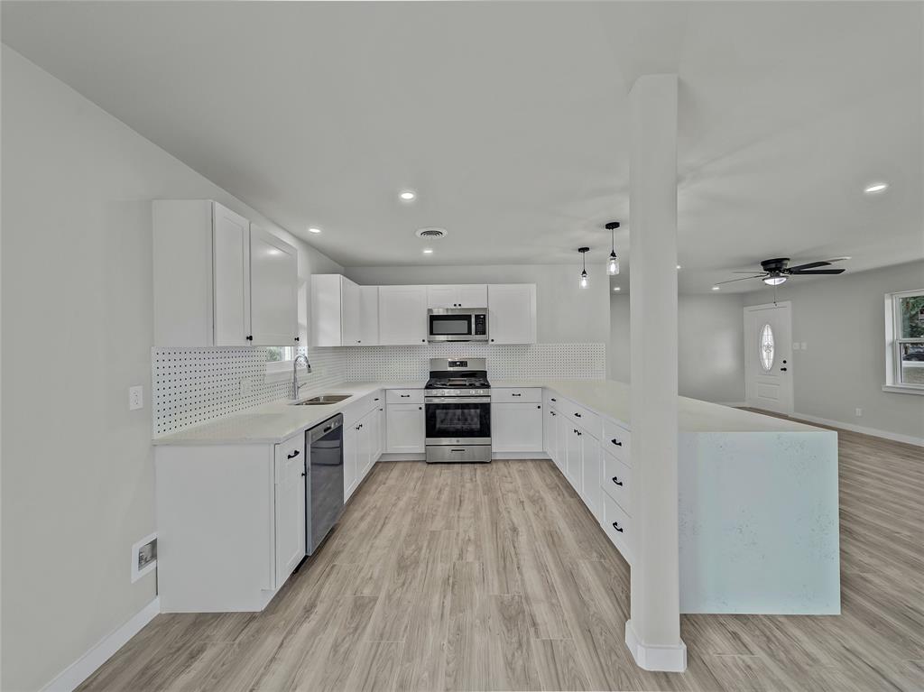 309 East Obuch Street Valley View, TX 76272 - Photo 11 of 24 Kitchen featuring appliances with stainless steel finishes, decorative backsplash, light countertops, light wood-style floors, and recessed lighting
