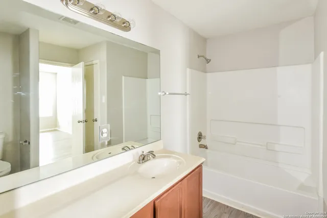 a bathroom with a tub sink and mirror