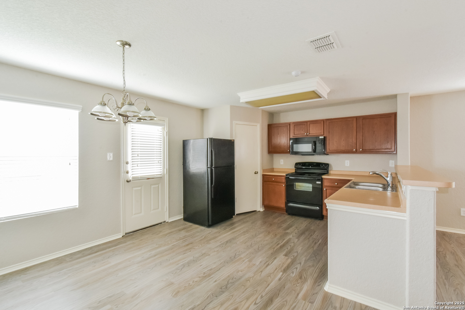 3603 Alonzo Fields Converse, TX 78109 - Photo 6 of 16 a kitchen that has a refrigerator a stove top oven a sink dishwasher and a dining table with wooden floor