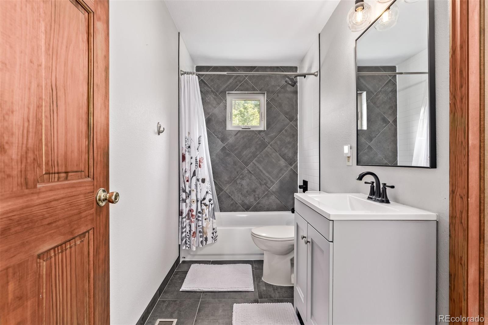 13950 Pine Valley Road Pine, CO 80470 - Photo 19 of 49 a bathroom with a sink a toilet a mirror and shower