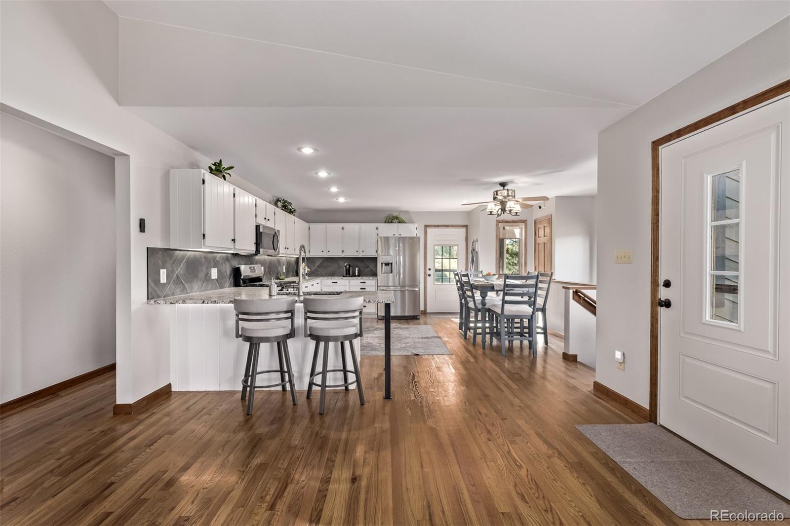 13950 Pine Valley Road Pine, CO 80470 - Photo 6 of 49 a kitchen with stainless steel appliances a dining table chairs stove microwave and cabinets
