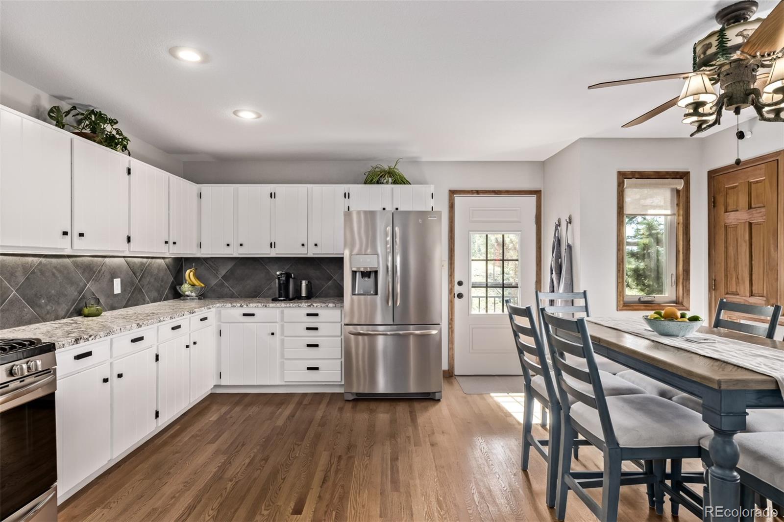 13950 Pine Valley Road Pine, CO 80470 - Photo 7 of 49 a kitchen with granite countertop a refrigerator and wooden floors