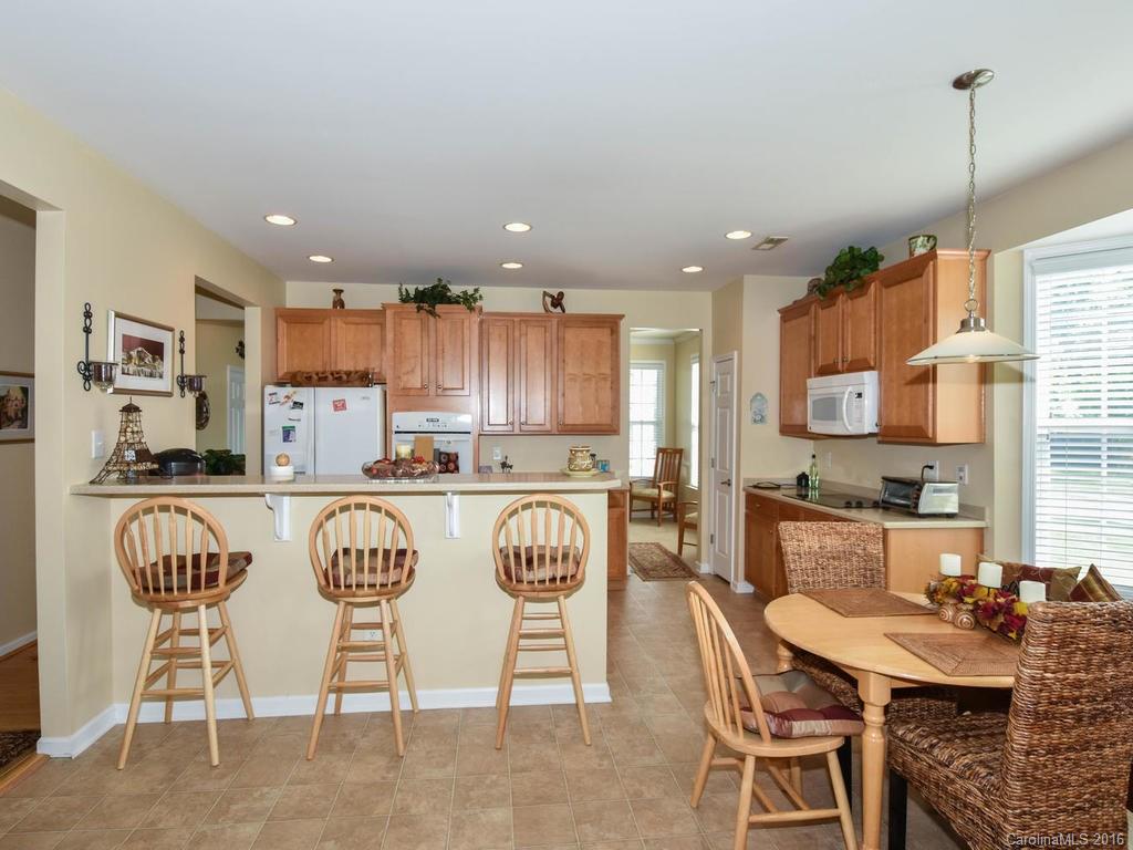 207 Garnet Court, Unit 561 Fort Mill, SC 29708 - Photo 10 of 21 a kitchen with stainless steel appliances granite countertop a kitchen island a stove a table and chairs