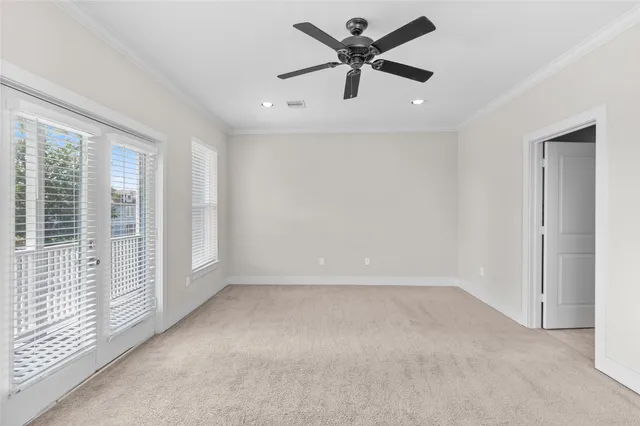 an empty room with windows and ceiling fan