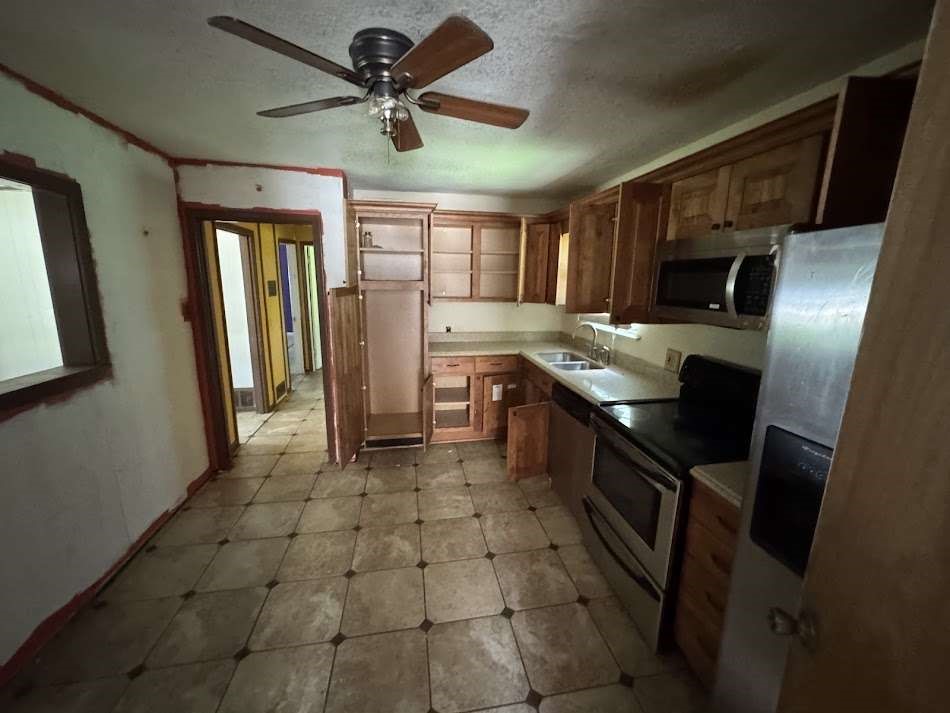 905 Euclid Street Cleburne, TX 76033 - Photo 7 of 15 a kitchen with stainless steel appliances granite countertop a sink a stove and a refrigerator