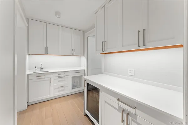 a kitchen with white cabinets and sink