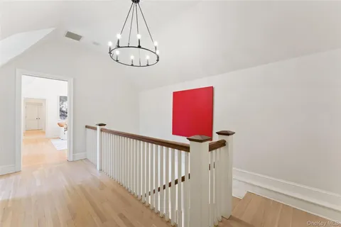 a view of a hallway with wooden floor and staircase