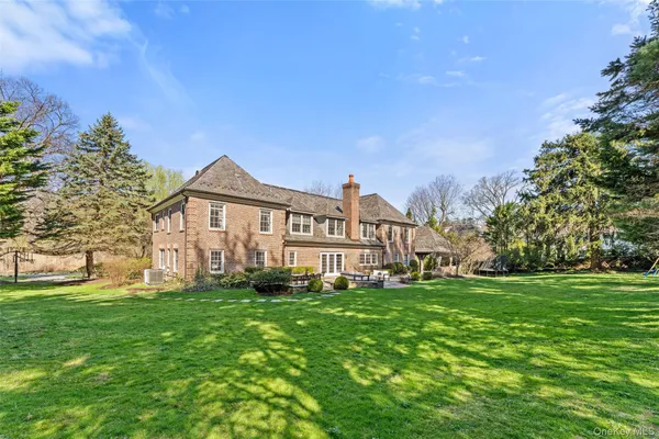 a front view of a house with a yard and trees