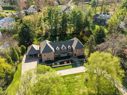 a aerial view of a house with a big yard and large trees
