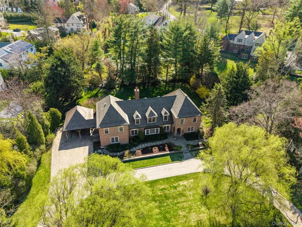 a aerial view of a house with a big yard and large trees